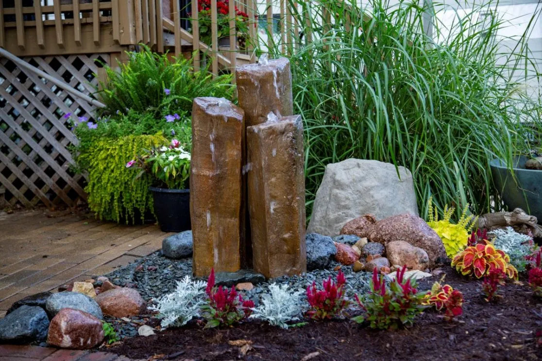 Faux basalt column fountain illuminated with optional color-changing lights for dramatic nighttime effect.