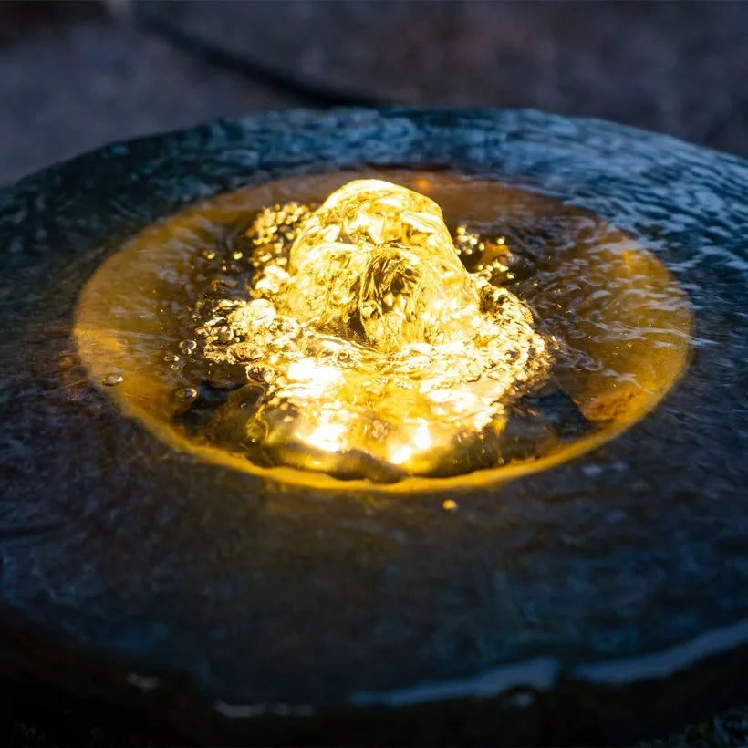 Aquascape Large Fountain Light illuminating a decorative fountain at night