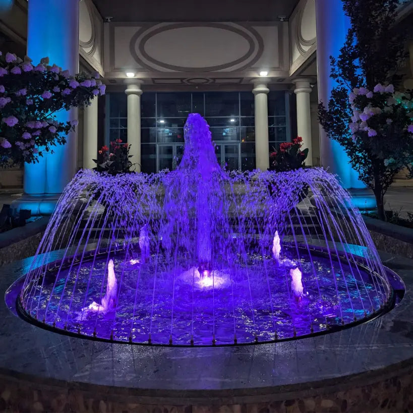 Fountain with purple lighting in an outdoor setting at night in Scarborough