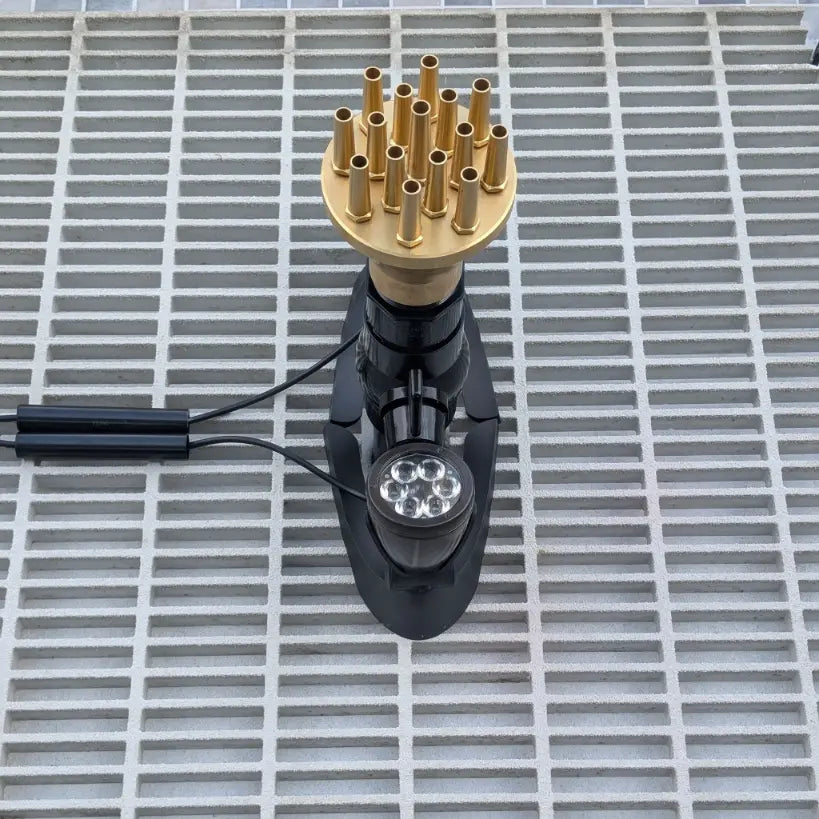 Gold column nozzle on a fountain sump pit grate with lights